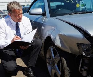 An insurance adjuster surveying a damaged car in Maryland.